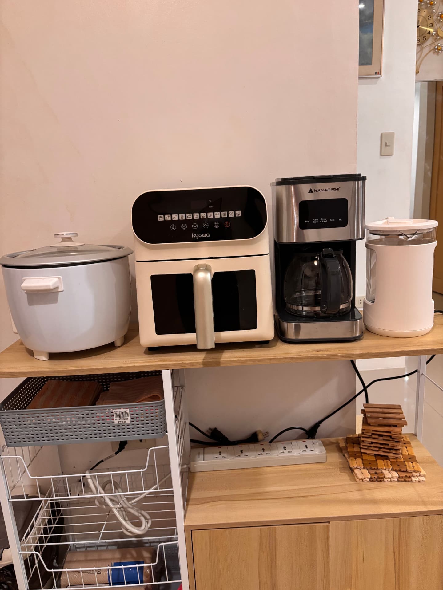 Rice cooker, air fryer, coffee maker, and electric kettle on a kitchen shelf