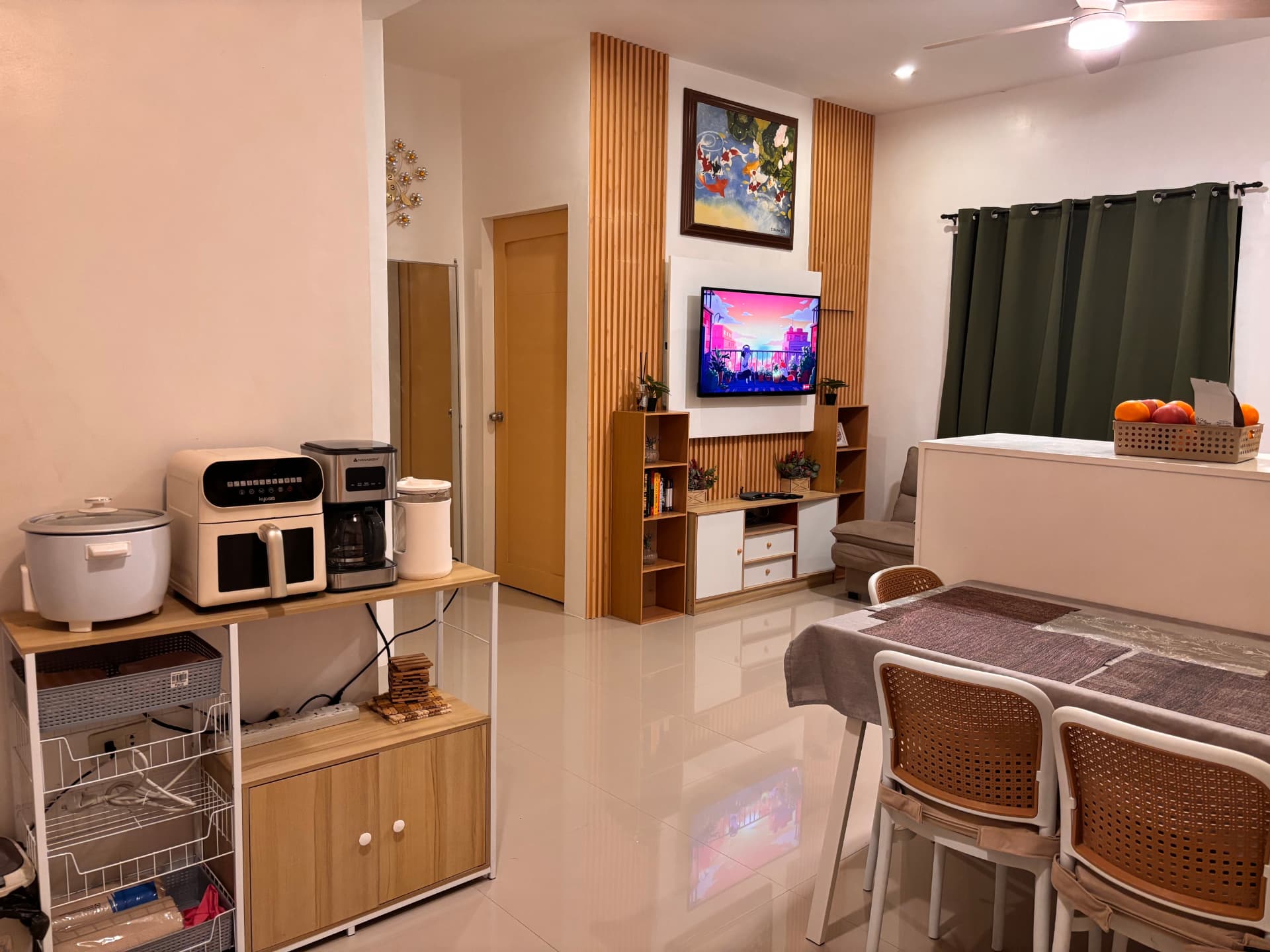 Open kitchen and lounge with smart TV, dining table, and small appliances