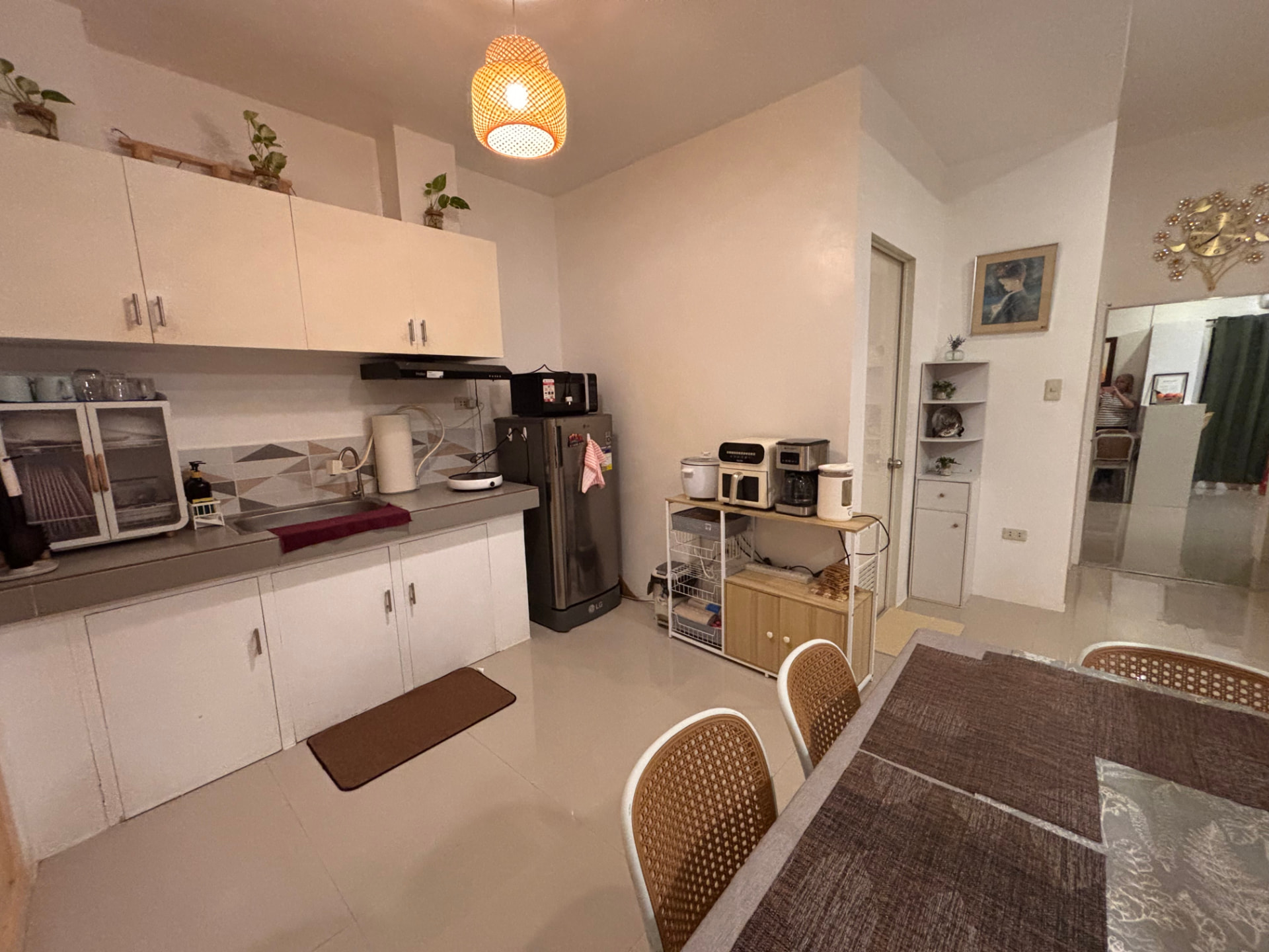 Kitchen with dining table, refrigerator, and warm pendant lighting